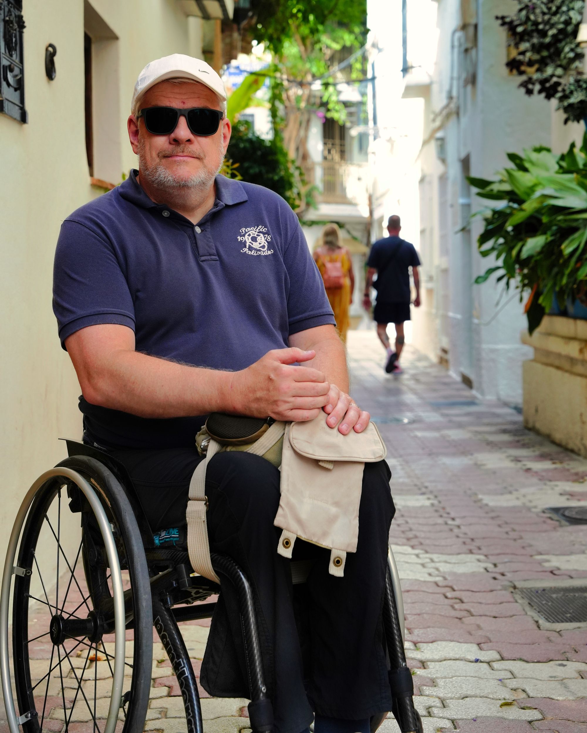 Photo of Per-Olof Hedvall. White, middle-aged man sitting in his wheelchair. Blue shirt, black pants.