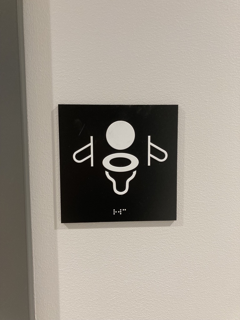 oilet sign with a water closet and a handrail.